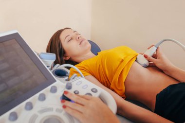 Doktor hasta yapıyor kadın abdominal ultrason. Ultrason tarayıcı bir doktor elinde. Tanılama. Ultrason 