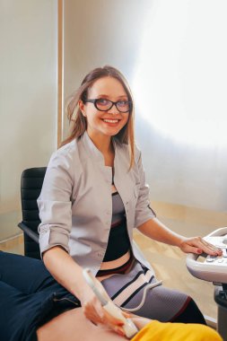 Doktor hasta yapıyor kadın abdominal ultrason. Ultrason tarayıcı bir doktor elinde. Tanılama. Ultrason 