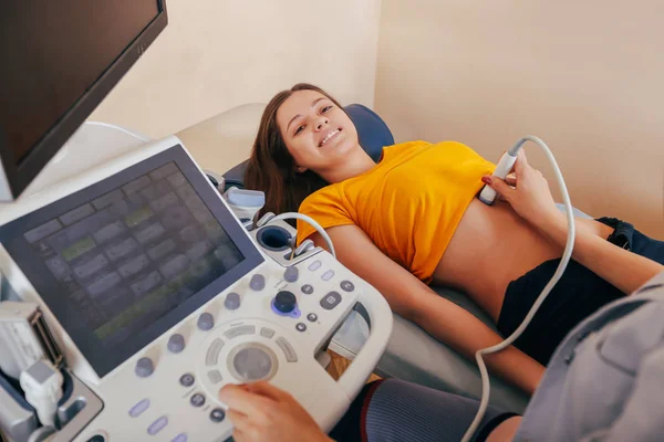 Doktor hasta yapıyor kadın abdominal ultrason. Ultrason tarayıcı bir doktor elinde. Tanılama. Ultrason 