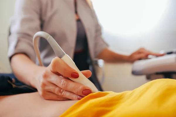 Doktor hasta yapıyor kadın abdominal ultrason. Ultrason tarayıcı bir doktor elinde. Tanılama. Ultrason 