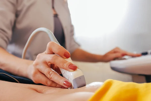 Doktor hasta yapıyor kadın abdominal ultrason. Ultrason tarayıcı bir doktor elinde. Tanılama. Ultrason 