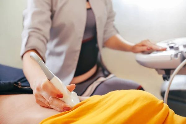 Doktor hasta yapıyor kadın abdominal ultrason. Ultrason tarayıcı bir doktor elinde. Tanılama. Ultrason 