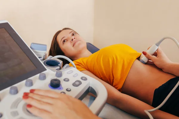 Doctor makes the patient women abdominal ultrasound. Ultrasound Scanner in the hands of a doctor. Diagnostics. Sonography — Stock Image Doctor Makes Patient Women Abdominal Ultrasound Ultrasound Scanner Hands Doctor Stock Image