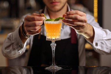 Buz küpleri ile kokco ekşi kokteyl içeceği. Siyah arka plan yüzeyinde kokco ekşi alkol kokteyli. Barmen Kokco ekşi alkol kokteyl içecek yapıyor