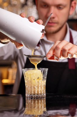 Buz küpleri ile batida kokteyl içeceği. Siyah arka planda batida alkol kokteyli. Barmen batida alkol kokteyl içecek yapıyor