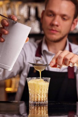 Buz küpleri ile batida kokteyl içeceği. Siyah arka planda batida alkol kokteyli. Barmen batida alkol kokteyl içecek yapıyor