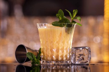 Buz küpleri ile batida kokteyl içeceği. Siyah arka planda batida alkol kokteyli. Barmen batida alkol kokteyl içecek yapıyor