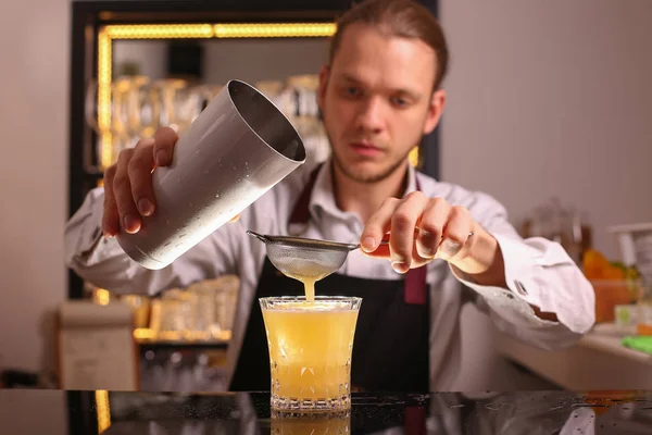 Whiskey Sour alcohol cocktail with orange slice and ice cubes on black mirror background made by man bartender