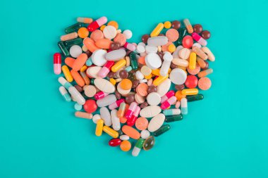 Kalp mavi arka plan üzerinde renkli haplar yapılmış, Kalp hastalığı ilaçları, Kalp Hastalığı için Ilaçlar