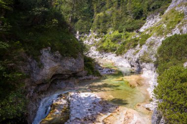 Yürüyüşçüler Leutaschklamm vadisini keşfeder, Leutascher Ache nehri tarafından oyulmuş doğal bir mucize. Ziyaretçiler çarpıcı şelale ve turkuaz havuzlarına tanık olmak için yolları ve köprüleri aşıyorlar..