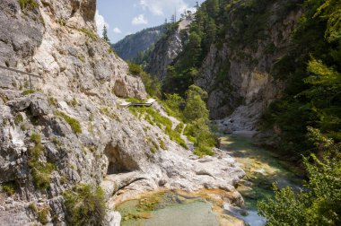 Almanya 'nın Mittenwald kentinde popüler bir yürüyüş merkezi olan Leutaschklamm vadisinin manzarası. Geçitte berrak bir nehir, ahşap geçitler ve çarpıcı kaya oluşumları yer alıyor..