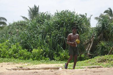 Wadduwa, Sri Lanka-Mayıs 06, 2018: bir bıçak kullanarak bir adam Sri Lanka 'da tropikal bir plajda taze bir Hindistan cevizi keser