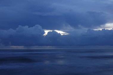 Güneşin batımında mavi bulutları olan okyanusun deniz manzarası. Sri Lanka Sahili