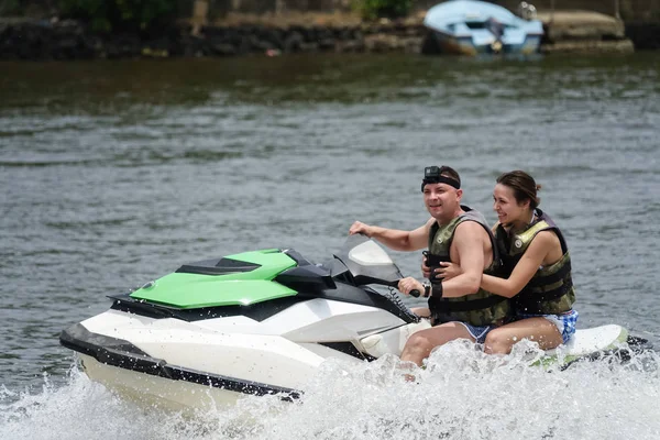 Mutlu genç çift zevk ve sahip eğlenceli bir jet ski üzerinde sürme. Tropikal Sri Lanka açıklarındaki