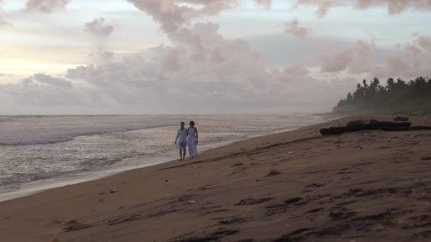 Pareja Joven Enamorada Camina Por Playa Atardecer Tomados Mano — Vídeo de stock