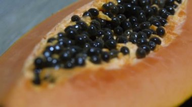 Taze dilimlenmiş papaya tohumları ile closeup içinde. Sarı papayanın yarısı. Kaydırma videosu