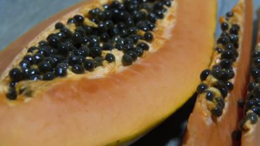 Taze dilimlenmiş papaya tohumları ile closeup içinde. Sarı papayanın yarısı. Kaydırma videosu