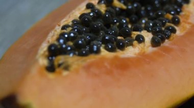 Taze dilimlenmiş papaya tohumları ile closeup içinde. Sarı papayanın yarısı. Kaydırma videosu