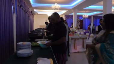 Wadduwa, Sri Lanka - 11 Mayıs 2018: İnsanlar tabakyemek alıyor. İsveç masası. Düğün ziyafet salonu. Sri Lanka'da geleneksel düğün