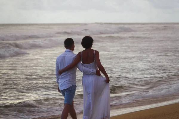 Jong stel in Love Walks op het strand bij zonsondergang — Stockfoto