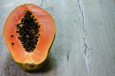 Ahşap bir arka plan üzerinde içinde tohumlar ile taze dilimlenmiş papaya