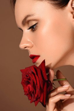 Güzel Stüdyo portresi. Altın sarısı, kırmızı dudaklı, bej arka planda kırmızı dudaklı, esmer kadın. Mükemmel bir cilt.