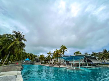 Yüzme havuzları ve palmiye ağaçları olan bir dinlenme alanı..