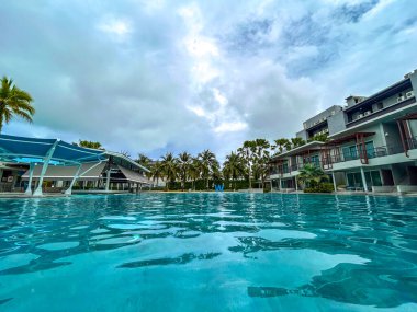 Yüzme havuzları ve palmiye ağaçları olan bir dinlenme alanı..