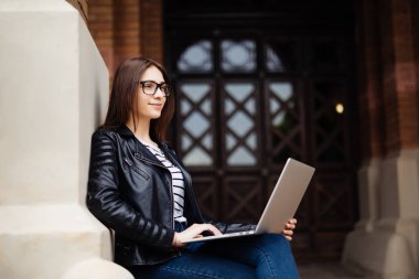 Genç öğrenci bilgisayar dizüstü bilgisayar ile Üniversitesi kampüsünde