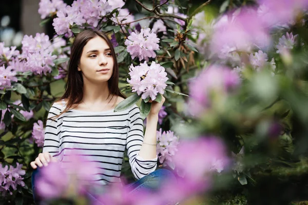 Young woman among the spring purple flowering branches