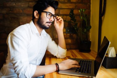 Bu okul online yapma programlama yakışıklı erkek öğrenci dizüstü bilgisayar klavye ücretsiz kablosuz internet bağlantısı ile kafede oturan yazarak kodlama egzersiz pratik.