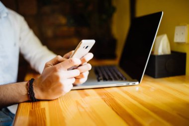 Yakışıklı iyi giyimli erkek uluslararası öğrenci dizüstü bilgisayar metin coffeeshop wifi ile otururken web kaynaklardan gelen bilgileri kullanarak ev ödevi için yaratıcı rapor yazarak konsantre.