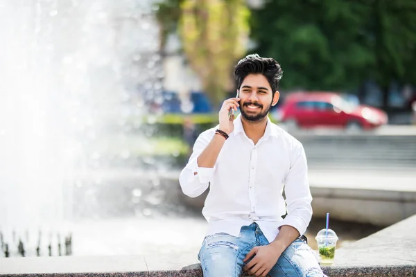 Ινδική Όμορφος Νεαρός Μιλάει Στο Τηλέφωνο Κάθεται Κοντά Σιντριβάνι Της — Φωτογραφία Αρχείου