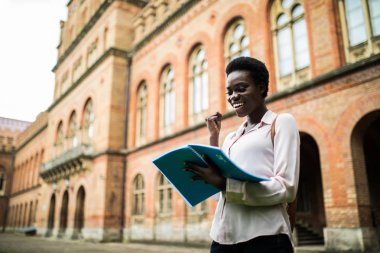 genç bir kız öğrenci kitaplığı atamalar yapıyor görüntü kadar yakın. ders notları alarak afro Amerikalı kadın.