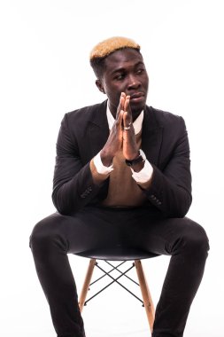 İş resmi kıyafeti üzerinde beyaz izole sandalye üzerinde oturan ciddi Afrika adam