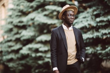 Bir takim elbisesi ve şehir sokakta yürürken telefon tutarak genç afro Amerikan adam