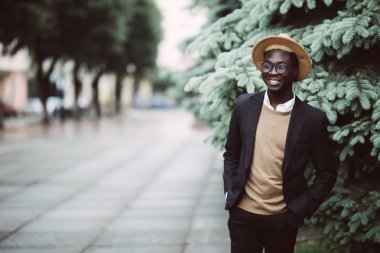 Yakışıklı Afro Amerikan adam rahat kıyafet ve açık havada sokakta yürürken güneş gözlüğü