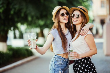 Mutlu brightful şehir sokakta sarılma iki şık kız olumlu anları. Eğleniyor portre portre komik neşeli attarctive genç kadın, gülümseyen, güzel anlar, en yakın arkadaşlarım