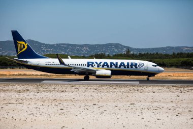 Faro, Portekiz - Temmuz, 2018: Ryanair gelen uçağı Faro havaalanından Fao gündüz çıkartıyor.