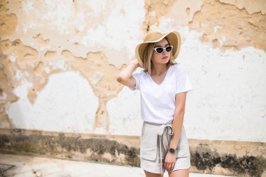 Zarif kadın iyi ruh hali dışında yürüyüş sırasında poz. Güneş zevk trendy yaz şapkalı memnun kız açık yakın çekim fotoğraf.