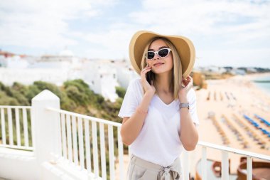 Mutlu smartphone kadın üzerinde dinlenirken Evet Avrupa tatil seaside resort Teras otel ya da evde açık.