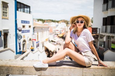 Panorama manzarayı genç turist Küpeşte şehir, üstüne oturan şapkalı