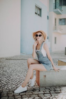 bir tezgah sokak şehir üzerinde oturan bir içki ile şapkalı bir kadın