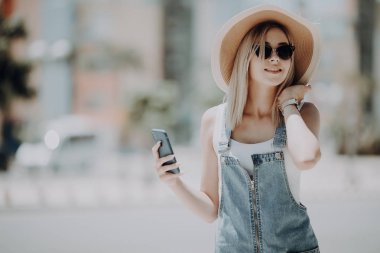 Genç kadın turist gps navigasyon telefonu kullanma sırt çantası ile şapkalı. Online rezervasyon. Yaz moda stil. Şehir turu. Dünyayı keşfedin. Seyahat için zaman.