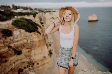 Lagos beach Güney Portekiz çarpıcı manzaraya karşı karşıya şapkalı kadın