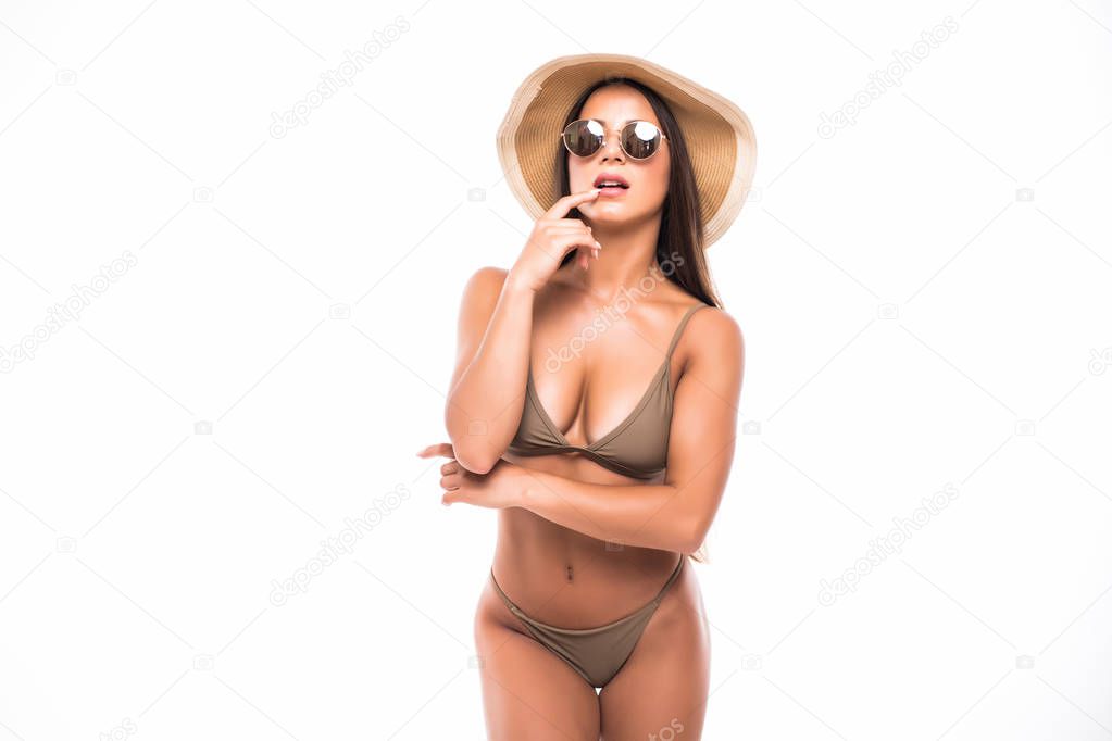 Half-length portrait of female wearing bikini, hat and sunglasses, isolated on white. Concept of summer holidays and traveling