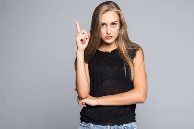 Tablet bilgisayar tutarak ve gri arka plan üzerinde izole ayakta iken de kopya alanı parmak işaret heyecanlı kadın