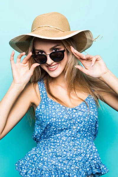 年轻漂亮的女人在夏季帽子和太阳镜在蓝色背景隔离的肖像 — 图库照片