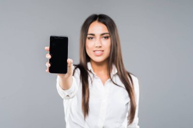 Boş ekran cep telefonu beyaz arka plan üzerinde izole işaret eden bir heyecanlı genç iş kadını portresi