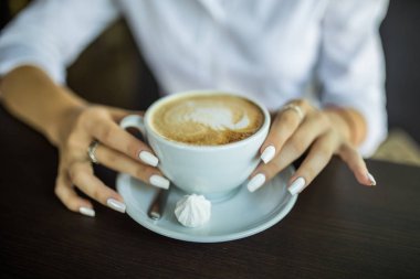 bir fincan kahve kafede tutan kadın kontrolden kapatın